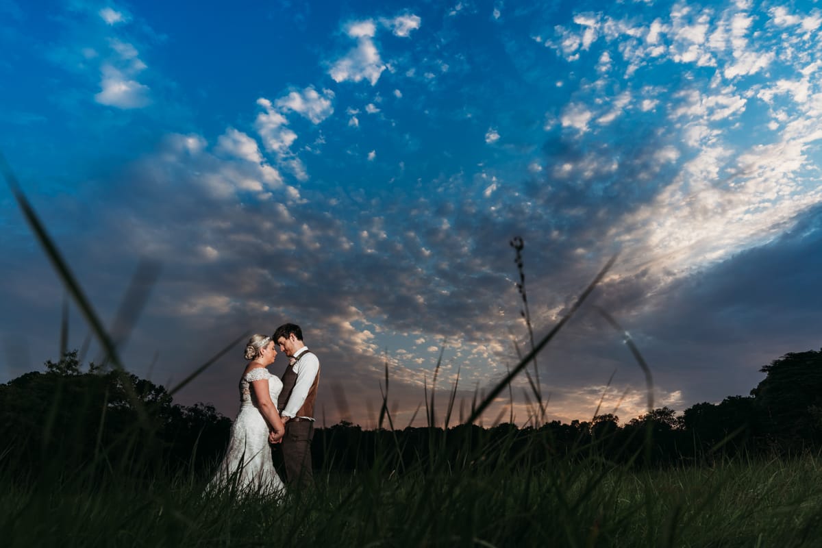 Sunset photo of bride & groom with Norwood Park in the background