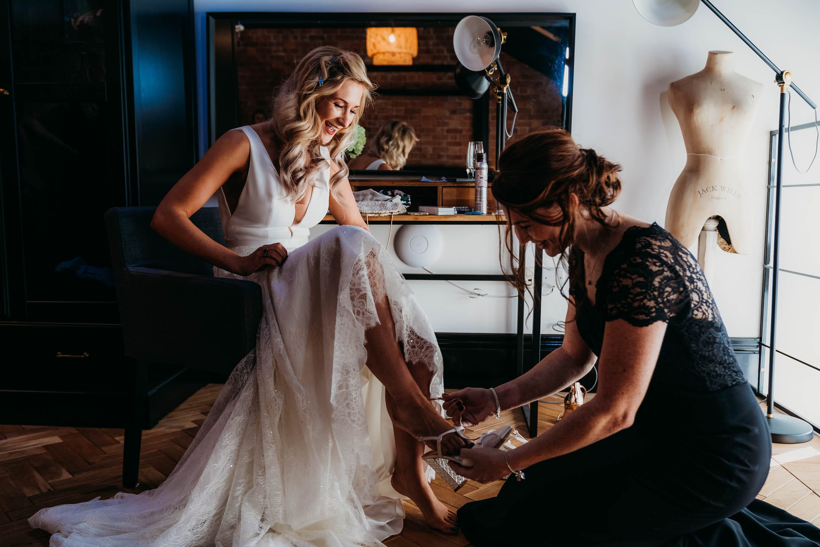 Bride putting on wedding shoes at Nottingham Wedding at Pumping House, Ollerton