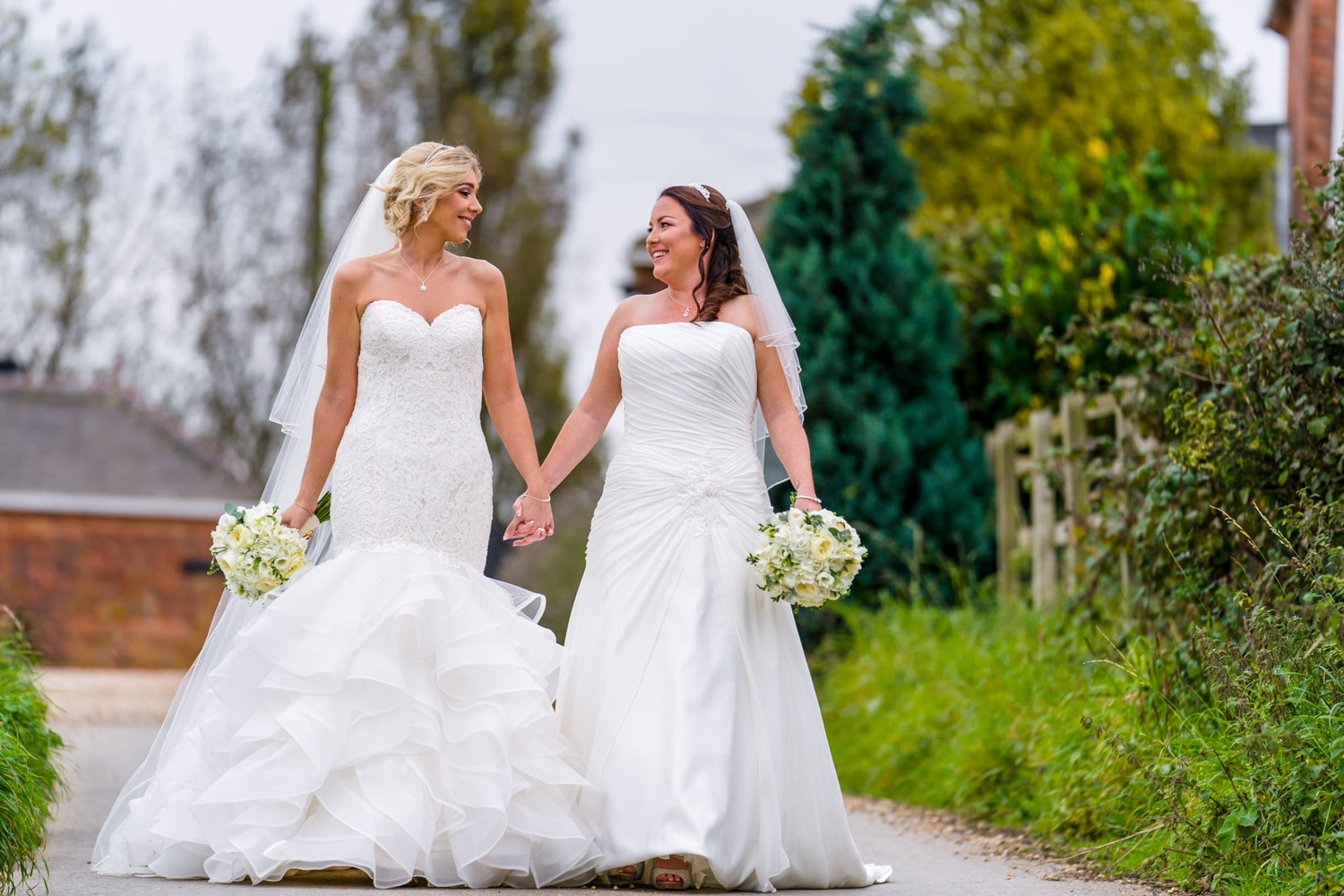 Two brides walking hand in hand at Swancar Farm