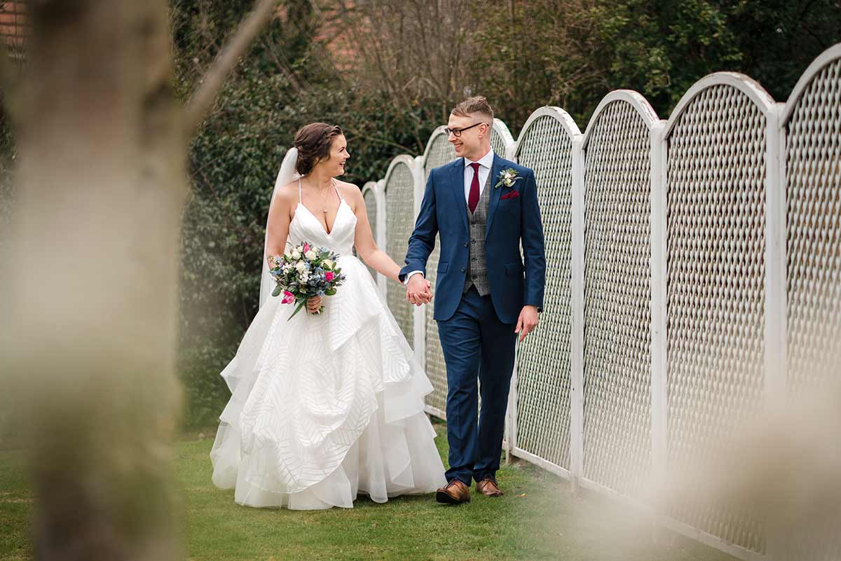 Bride & groom walking hand in hand at the Old Vicarage Boutique Hotel in Nottingham