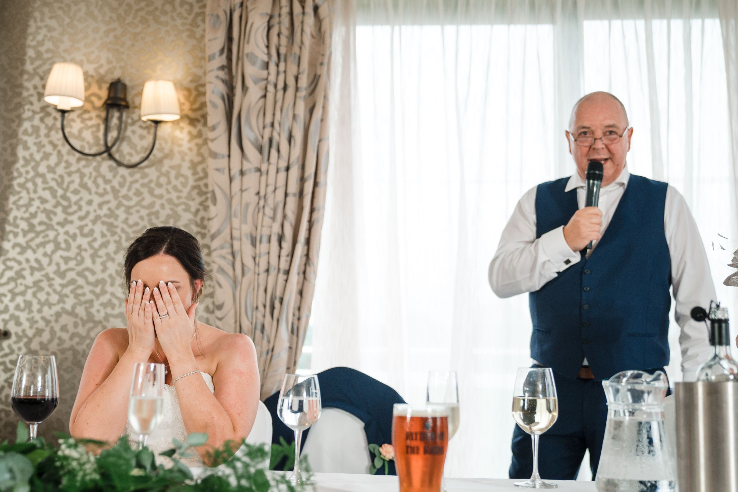 Bride covers face during Father of Bride speech