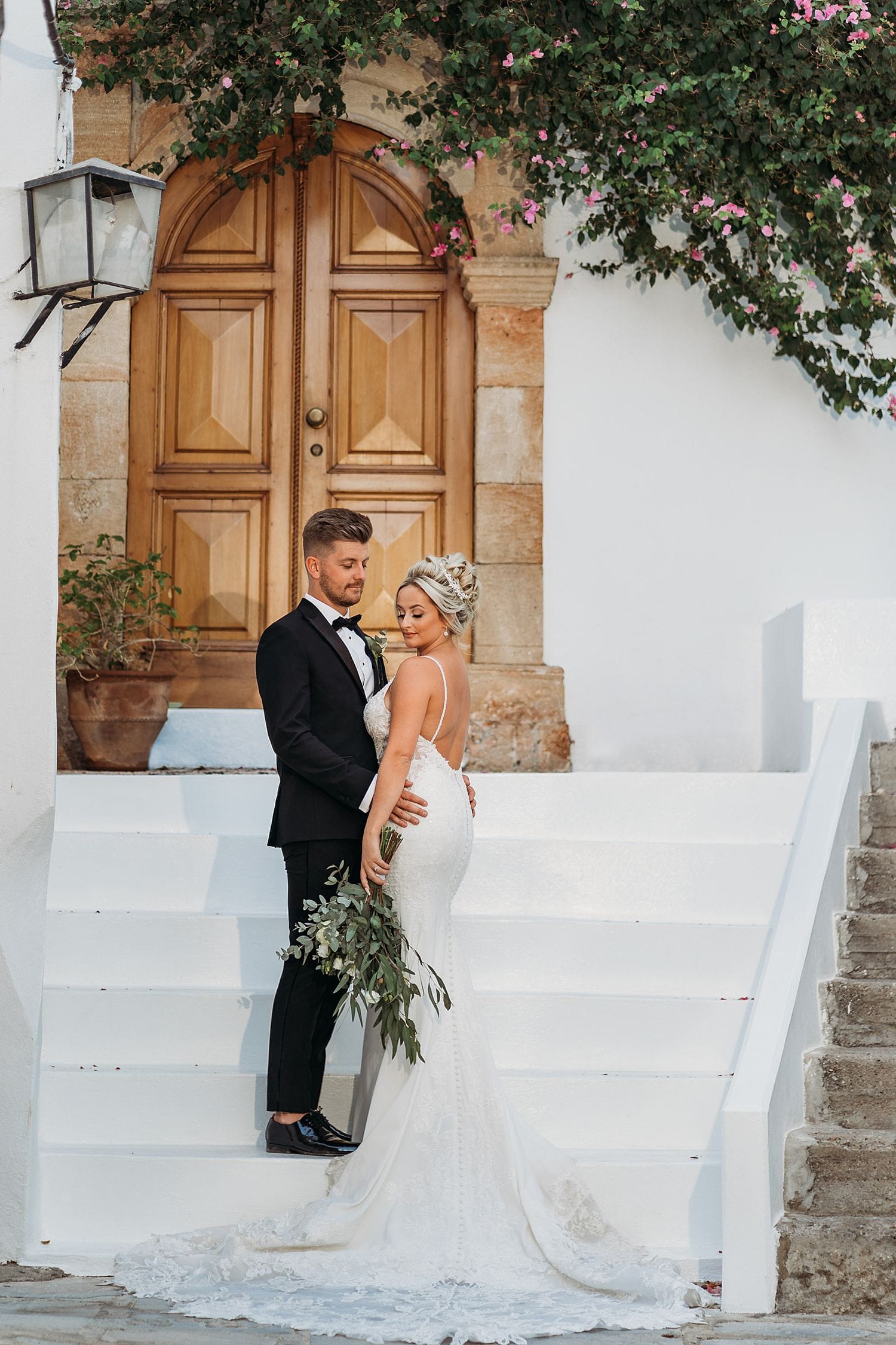 wedding photo of beautiful bride and groom stood in a doorway at Lindos