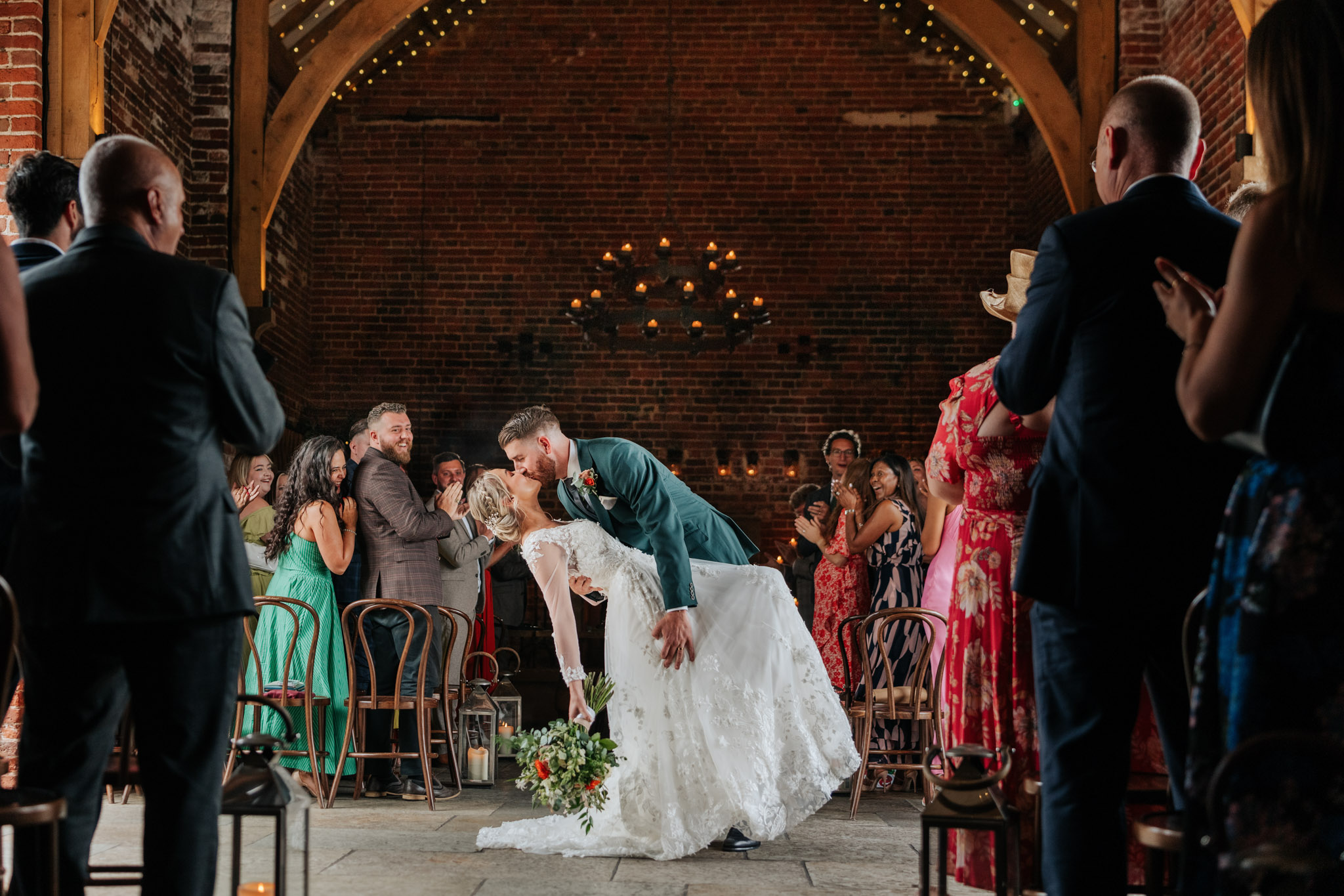Bride & groom perform a stunning dip kiss whilst exiting from their wedding ceremony at Hazel Gap Barn