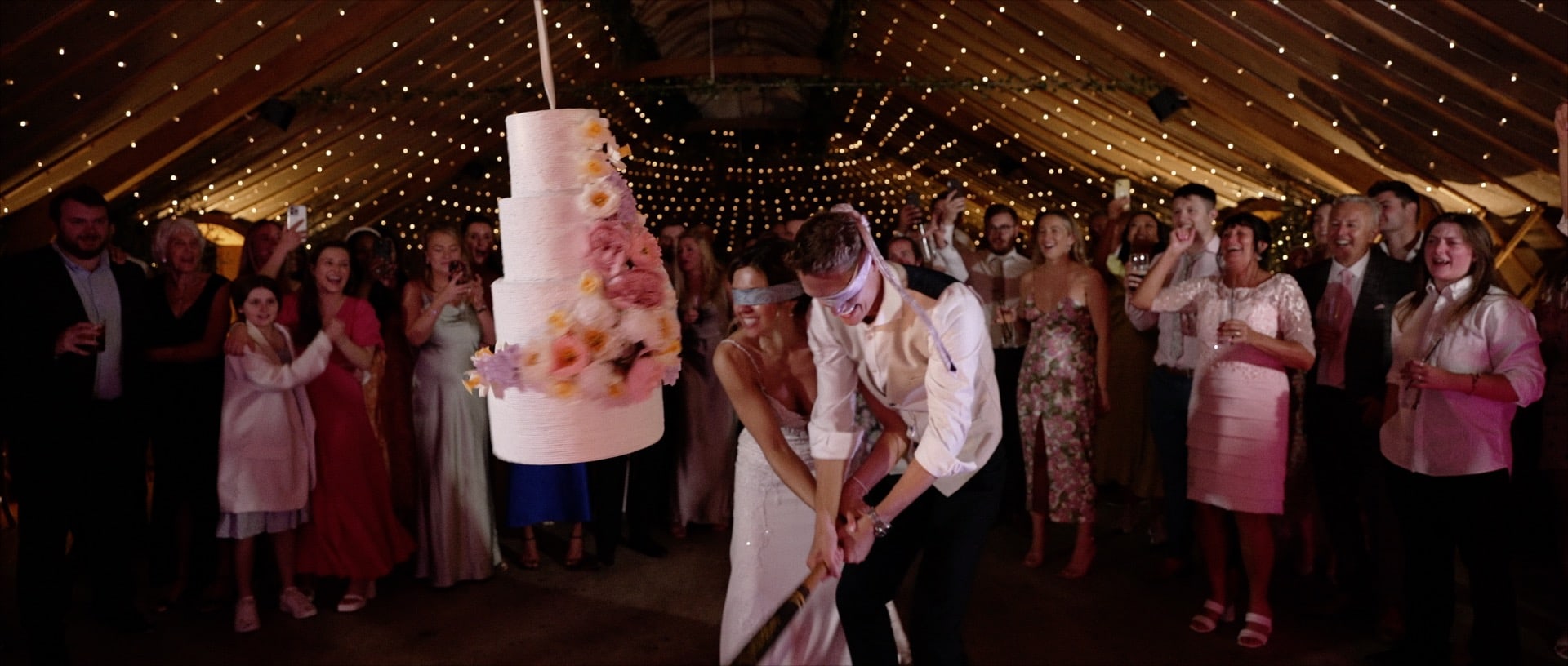 Bride and groom smashing wedding cake pinata at Thorpe Garden
