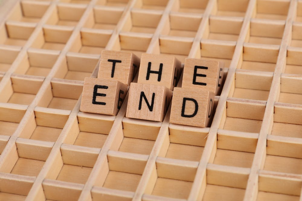 The end written in dice on a wood block