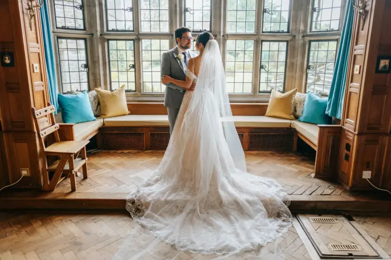 Back of beautiful wedding dress stood in the library inside Tissington Hall