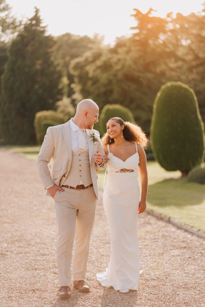 Newlywed couple walking around Prestwold Hall gardens during golden hour